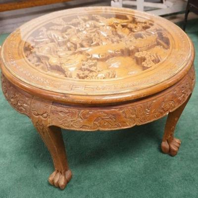 1064	HEAVILY CARVED ASIAN ROUND GLASS TOP TABLE W/3 DIMENSIONAL CARVING UNDER GLASS TOP, APPROXIMATELY 32 IN X 20 IN HIGH
