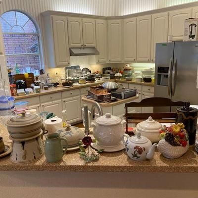Kitchen filled with appliances, pottery, glasses, pots, pans and more