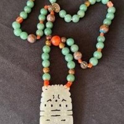 Vintage Jade and Coral Beaded Necklace accented with a lovely carved pendant

Measures about 28 inches long. 