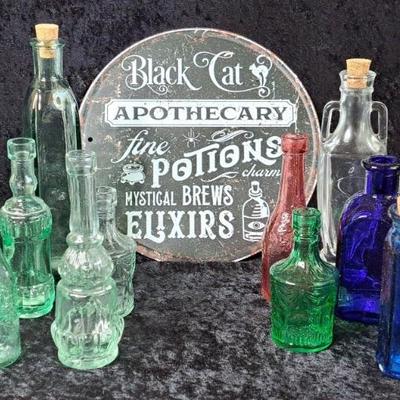 Collection Of Glass Bottles And Metal Apothecary Sign