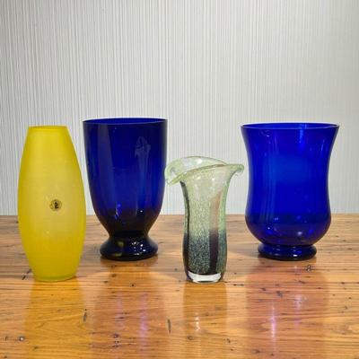 (4PC) COLORED GLASS VASES | Including: 2 cobalt glass vases, colorful art glass vase with purple and green shading, and hand blown yellow...