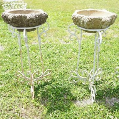 1234	PAIR OF WROUGHT IRON PLANT STANDS WITH CONCRETE PLANTER INSERTS, HAVING EMBOSSED CHERUB FARIES AROUND EXTERIOR, APPROXIMATELY 18 IN...