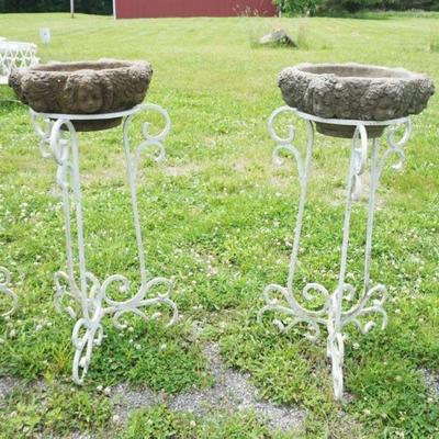 1233	PAIR OF WROUGHT IRON PLANT STANDS WITH CONCRETE PLANTER INSERTS, HAVING EMBOSSED CHERUB FARIES AROUND EXTERIOR, APPROXIMATELY 18 IN...
