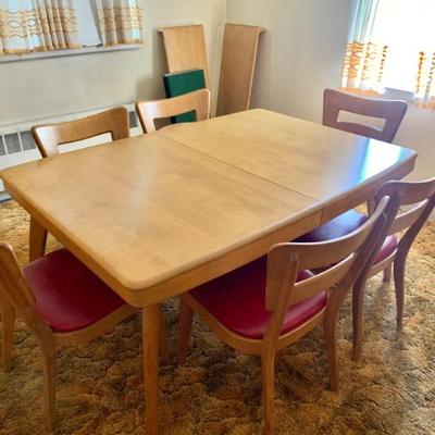 Heywood Wakefield dining table w/ set of six chairs. Table is in excellent condition and has 2 leaves and a full set of table pads.