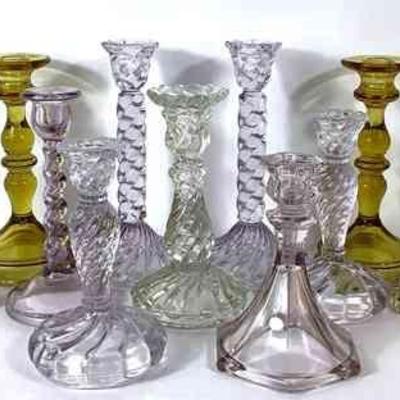 DILA213 Assortment Of Candlesticks	Fostoria colony pattern with a slight lavender tint. Couple of amber color. McKee 