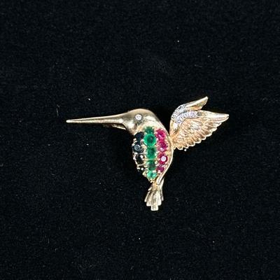 DIAMOND EMERALD SAPPHIRE & 14K GOLD BIRD PIN | Designed as a 14K gold hummingbird-form pin/brooch set with melee diamonds, emeralds,...