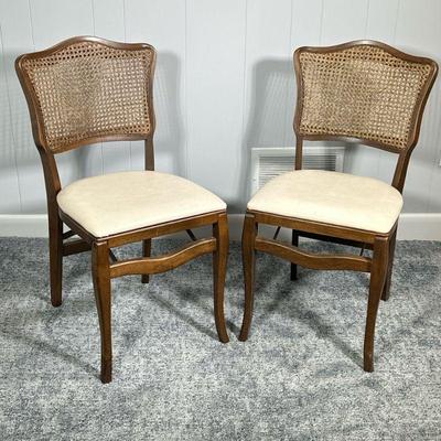 (2PC) PAIR STAKMORE FOLDING GAME CHAIR | Having cane back over cream cushioned seat with walnut finish, made by Stakmore Furniture of...
