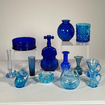(13PC) COLLECTION OF BLUE GLASS | Including small vases, pitchers, a cello form bottle, etc. - l. 4 x w. 1.5 x h. 8 in

