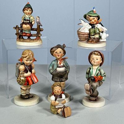 (6PC) SMALL HUMMEL FIGURINE LOT | Including: Playmates Hum 58/0, Girl With Sheet Music Hum 389, Wayside Harmony Hum 3/0, School Girl Hum...
