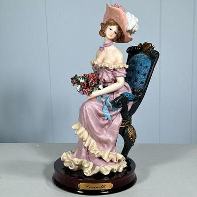 GIUSEPPE ARMANI STYLE FIGURINE | “Casinelli” female figurine holding bouquet of flowers on wood base, in the style of Guiseppe Armani. -...