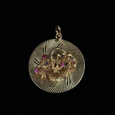 SAPPHIRE & 14K GOLD FLOWER PENDANT | Designed as a 14K gold circular pendant with basket of flowers set with blue and pink sapphires,...