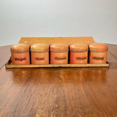 (5PC) TIN SPICE JARS WITH WALL RACK | A set of five tin spice canisters, each labeled: Ginger, Cloves, Cinnamon, Allspice, Nutmeg; with a...