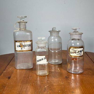 (4PC) RECESSED LABEL APOTHECARY JARS | Glass apothecary jars, three with labels. - h. 10 in (tallest)

