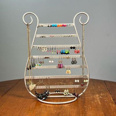 LARGE LOT JEWELRY & JEWELRY STAND | Costume jewelry, including multiple pairs of earrings, necklaces and more on a harp-form jewelry...