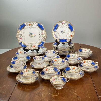 COBALT DINNER WARE | China set with gilt and cobalt floral rims, including 12 cups, 11 saucers, 9 small plates, and 2 serving plates. -...