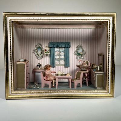 FRAMED DOLL HOUSE DIORAMA | Showing a teatime scene in a pink room with miniature furniture, dolls, and cat in a gilt shadowbox frame. -...