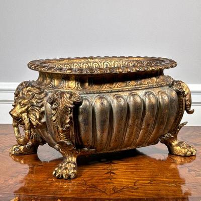 COMPOSITE LION BASIN | Composite and gilt basin with mounted lions head rings and claw feet. - l. 16.5 x w. 9 x h. 8 in

