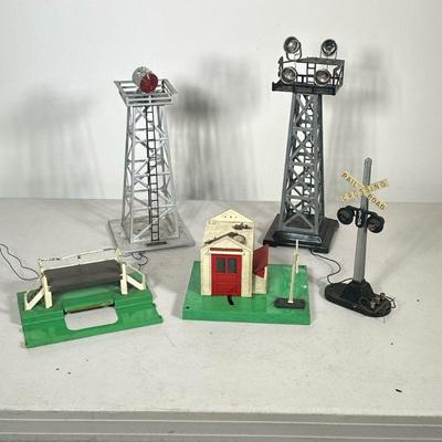 LIONEL TRAINS SET PIECES | Including: rotating searchlight tower, light tower, powered railroad crossing sign, Lionelville signalman, and...