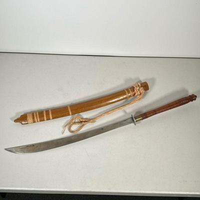 REPLICA CURVED SWORD | Replica curved sword with wave maker marks and wood sheath. - l. 33 x w. 1.75 in

