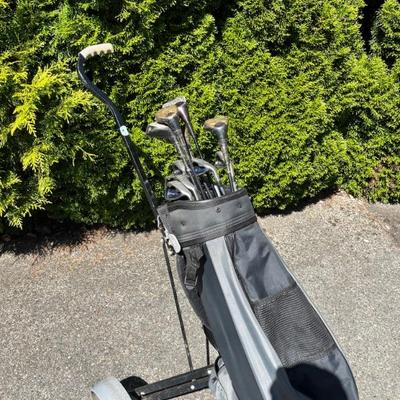 Set of golf clubs, bag, and pull cart
