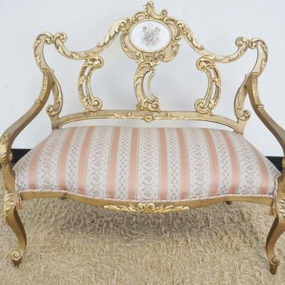 1120	FRENCH CARVED GILT WOOD DECORATED SETTEE WITH OVAL HAND PAINTED PORCELAIN PLAQUE DEPICTING CHERUBS, APPROXIMATELY 40 IN X 20 IN X 37...