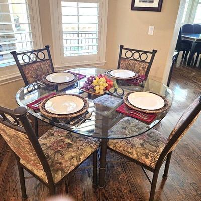 Lot #21 - Wrought Iron Glass Top Kitchen Table W/ Four Matching Upholstered Chairs - 48" Diameter Rounded Square Top