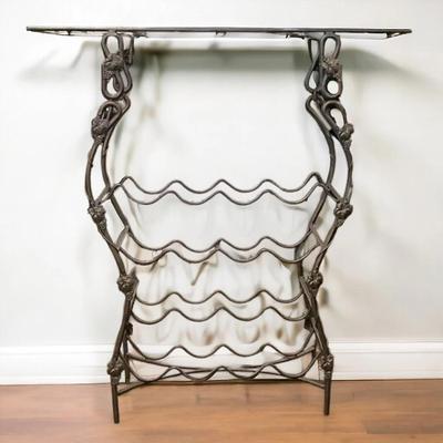Decorative metal wine rack featuring a glass top shelf.