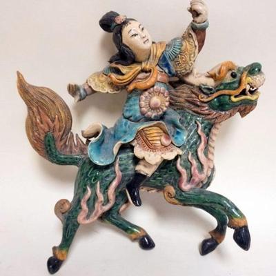 1159	ASIAN GLAZED POTTERY WALL HANGING WITH IMAGE OF PERSON RIDING FOO DOG , APPROXIMATELY 11 IN H WITH REPAIRS

