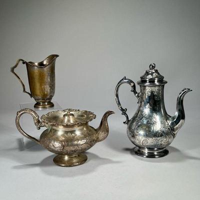 (3PC) SILVER PLATE ITEMS | Including an engraved coffee pot with fruit finial, an engraved teapot, and a small open pitcher. - l. 9 x h....