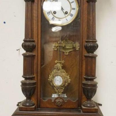 1122	GERMAN WALNUT WALL CLOCK W/ENAMELED FACE APPROXIMATELY 4 IN X 8 IN X 35 IN HIGH
