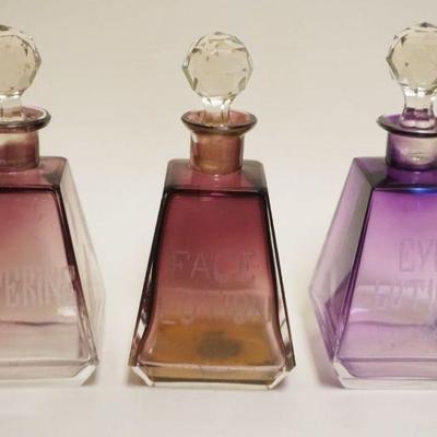 1005	AMETHYST TO CLEAR PYRAMID SHAPED TOILETRY BOTTLES W/ENGRAVED EYE LOTION, FACE LOTION & LISTERINE, EACH APPROXIMATELY 6 1/2 IN HIGH
