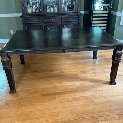 Ashley Furniture DR Table | Striking dining room table with a mahogany finish in the Ledelle Series by Ashley Furniture. Carved corners...