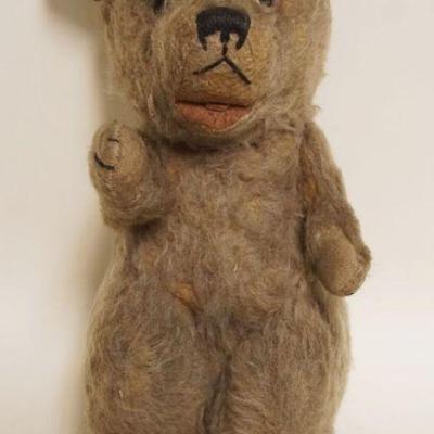 1064	ANTIQUE TEDDY BEAR, JOINTED ARMS & HEAD W/GLASS EYES, APPROXIMATELY 11 IN HIGH
