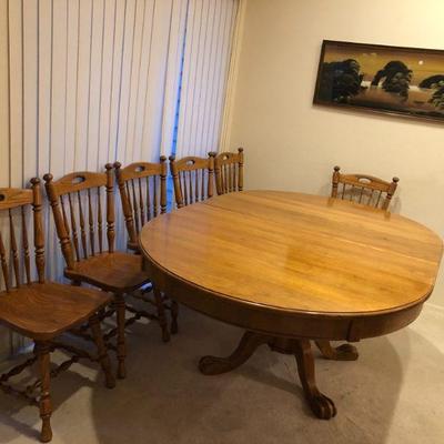 Oak Pedestal Dining Table shown with two leaves inserted.