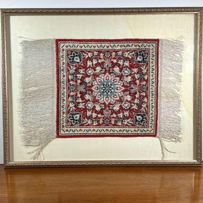 FRAMED MINIATURE RUG | Having central medallion with red backing a flower design. - l. 24 x w. 19 in

