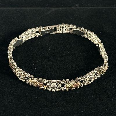 12K GOLD & STERLING BRACELET | Designed as a sterling silver bracelet with alternating links mounting chased 12K yellow and rose gold...