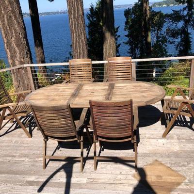 Oval Teak Umbrella Table. L 94.1/2in | W 42.1.2in | H 28in. (6 Teak Patio Arm Chairs - SOLD).