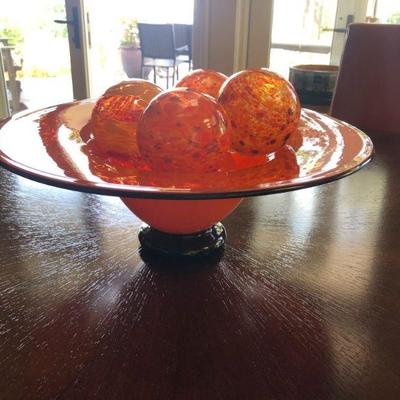 Hand Blown Glass Bowl and Floats by Dehanna Jones, 2000. Footed Orange Bowl is 5.3/4in Tall | 16in Diameter Rim. There are 5 Orange Floats.