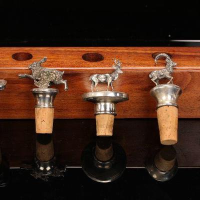 5 Sterling silver bottle stoppers in wooden display rack