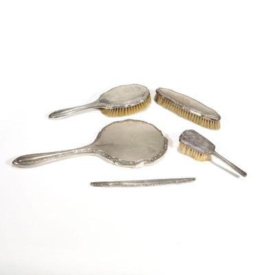 (5pc) CONTINENTAL SILVER DRESSER SET | A four piece continental 800 silver dresser set comprising a hand mirror, two brushes, and a comb...
