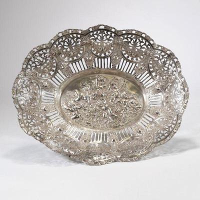 CONTINENTAL SILVER OPENWORK BASKET | 800 silver basket / tray of large size with intricate reticulated rim and repousse scene of putti in...