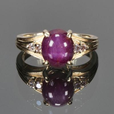 NATURAL PURPLE STAR SAPPHIRE, DIAMOND & GOLD RING | Designed as a central purple star sapphire (9.1 x 7.6 x 5.95 mm), flanked by two...
