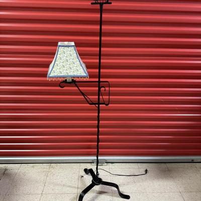 Vintage black metal adjustable lamp featuring floral lampshade and courtship figures. Adjustable in height. Measures 65” tall and 20”...