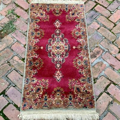 Vintage hand knotted rich deep fuchsia color wool carpet. Measures 49” x 25”.