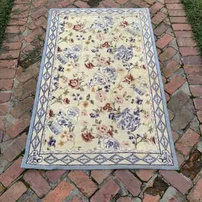  Vintage hand knotted wool carpet with floral and chinoiserie pattern featuring blue and white pots. Measures 65” x 41”. 