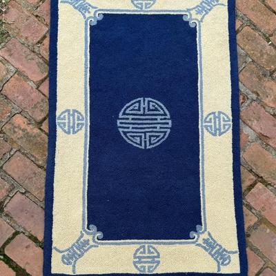 Blue and white hand hooked wool chinoiserie carpet measures 49” x 29”. 