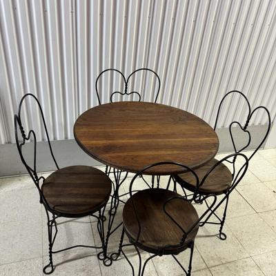 Antique Ice Cream Shoppe Table And Chair Set. Solid wood table top with wrought iron metal base with four matching chairs. The table...
