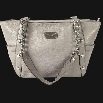 KAAR233 Michael Kors Ladies Leather Satchel	Michael Kors light-med grey handbag. Accented with metal studs chain link straps.
