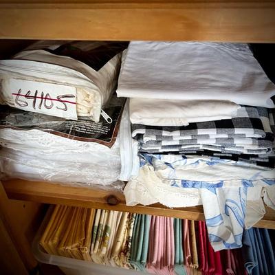 Pine armoire filled with linens (tablecloths, runners, napkins, and placemats) and fabric remnants