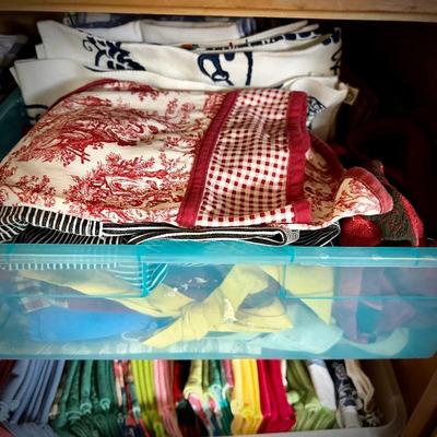 Pine armoire filled with linens (tablecloths, runners, napkins, and placemats) and fabric remnants